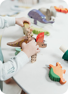 Child playing with wooden animals